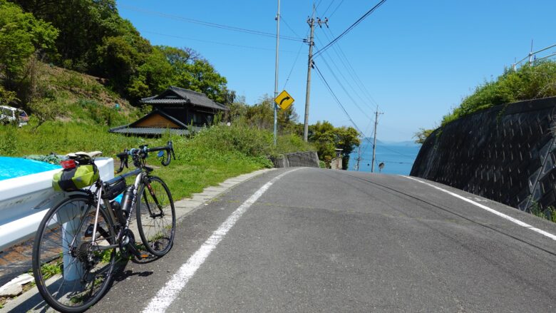 坂道を上っていると遠くに海が見えた風景