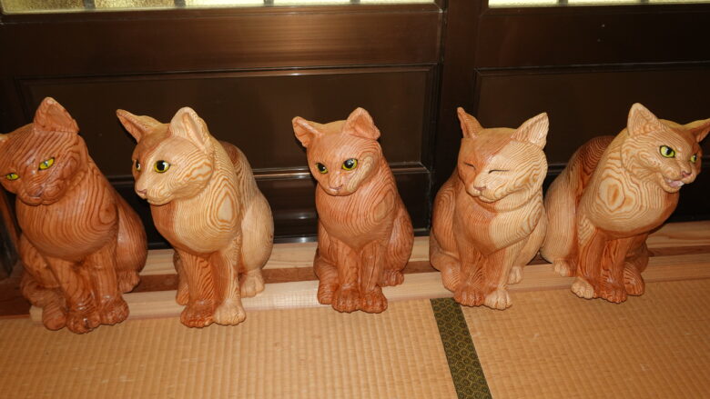 ちょこんと座る木彫りの猫の可愛さよ