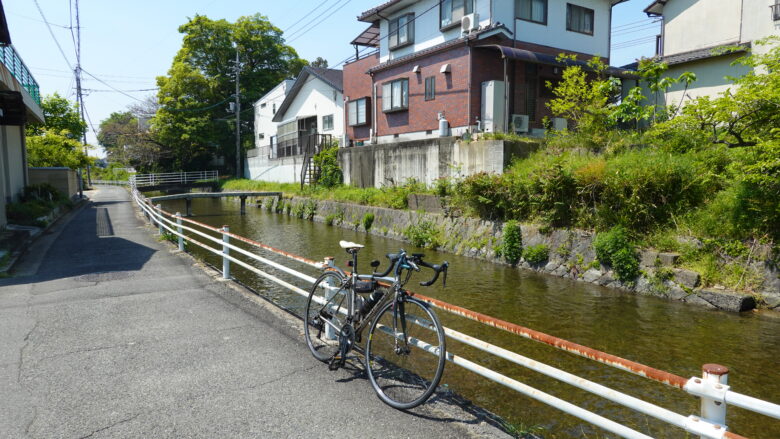 小川のそばを自転車で走る