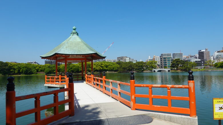 晴天の下、池に浮かぶ浮見堂が映える