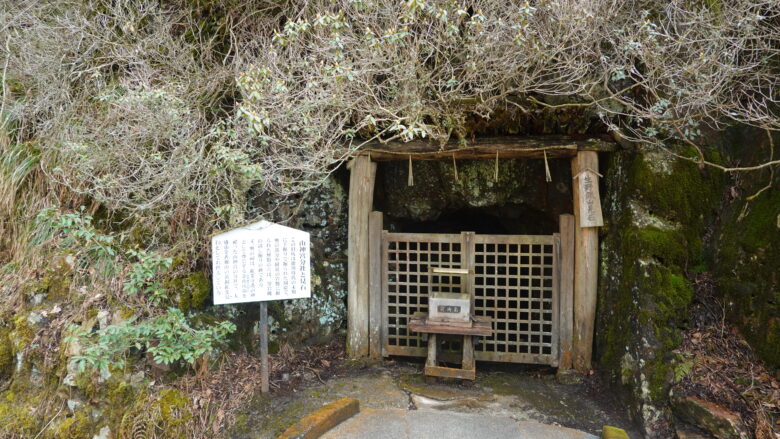 小さな坑道、手前には賽銭箱がある