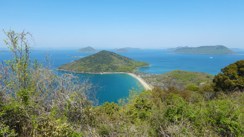 真っ白な西浜とおにぎりの形をした阿島山の景観よ