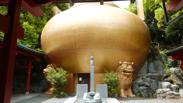 シーサーがマントラ塔を担いでいるにように見える